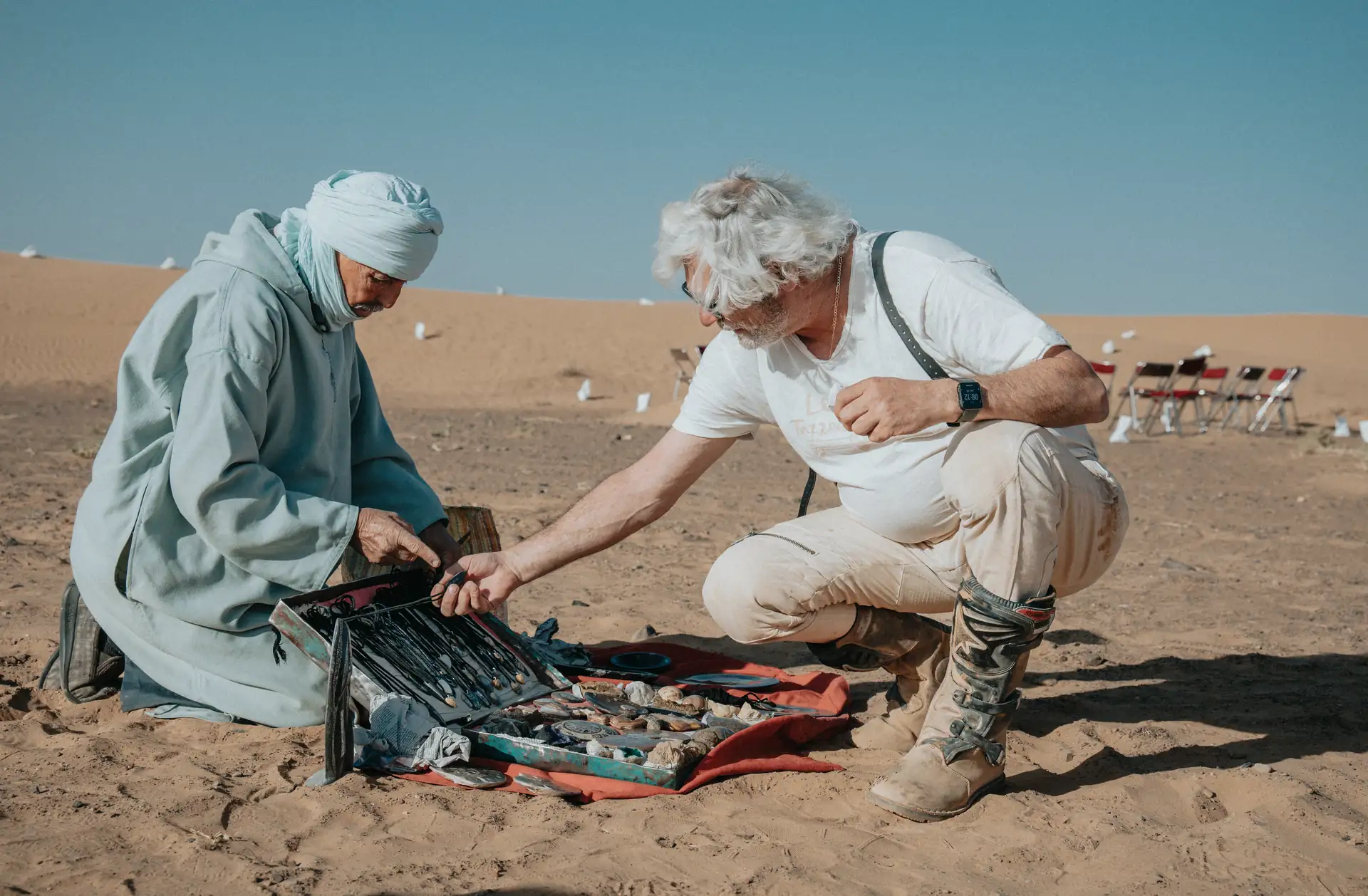 Local Berber guide showing desert fossils and minerals to a traveller in the Sahara