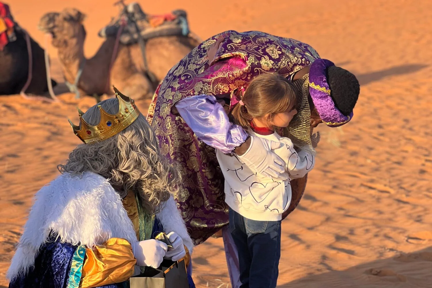 Une petite fille accueille les Rois mages et leurs cadeaux dans les dunes